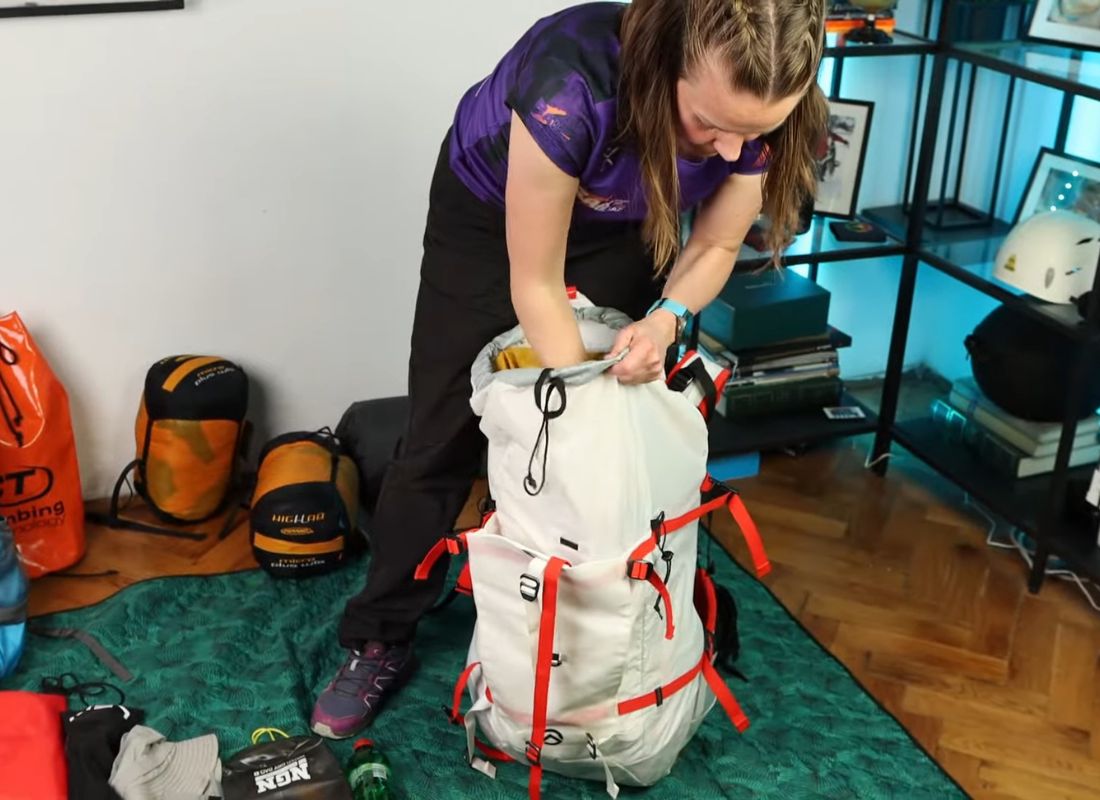 devojka pakuje ranac za planinarenje 